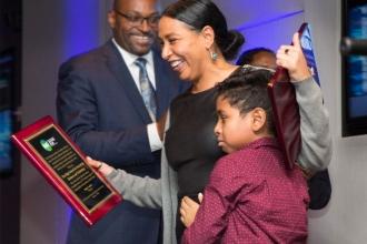 Woman reacts to winning award, her son is nervous. 