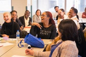 Members are laughing at something said during a presentation. 
