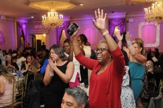 Staffers from PS 169 in the Bronx rise from their seats to cheer student honoree Amyra Davis at the UFT District 11 Scholarship Dinner