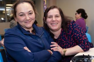 School nurse colleagues take a photo while seated at a table during the 2025 UFT School Nurses Appreciation Dinner at UFT headquarters. 