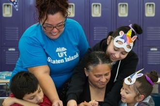 Two women working with kids on project